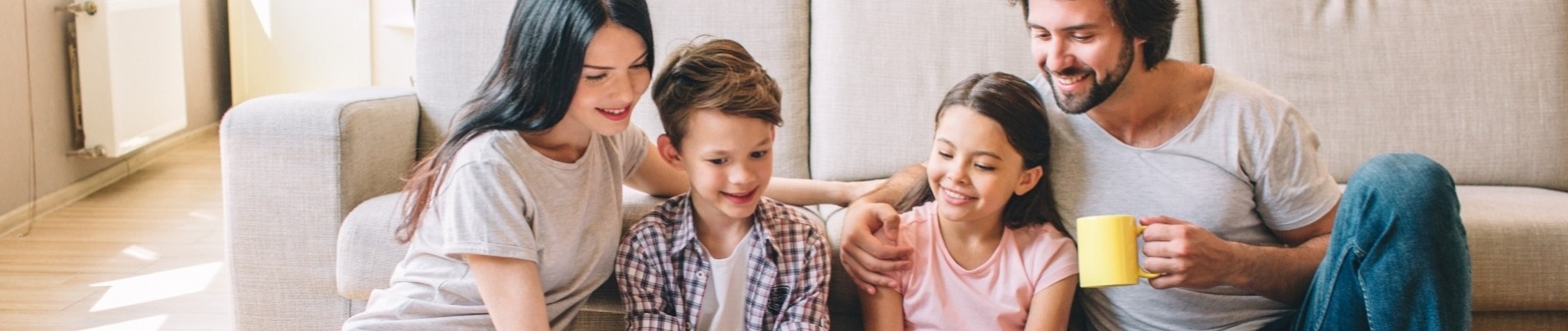 Familie, 2 ouders, 2 kinderen lezen samen in een boek 